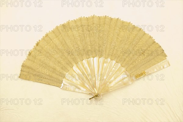 Fan, c. 1870, France, Etched mother-of-pearl sticks and guards, point de gaze mount, backed with gauze, rhinestone rivet, gilt loop, 24.1 cm (9 1/2 in.)