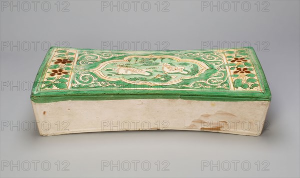 Rectangular Pillow with Mandarin Ducks in a Lily Pond, Jin dynasty, (1115–1234), late 12th/13th century, China, Cizhou ware, earthenware, slip-coated with green and amber-yellow glazes and carved and incised decoration, 39.6 × 18.0 × 11.0 cm (15.6 × 7.1 × 4.3 in.)