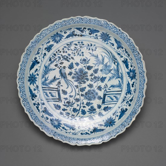 Shallow Dish with Long-Tailed Birds in a Garden of Stylized Peonies and Fronds, Encircled by a Scrolling Wreath of Camellia and Lotus Blossoms, Yuan dynasty (1279–1368), early/mid–14th century, China, Porcelain painted in underglaze blue, H. 7.9 cm (3 1/8 in.), diam. 45.4 cm (17 7/8 in.)