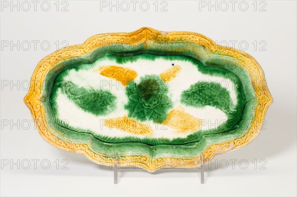 Elongated Foliate Dish with Fish and Central Floret, Liao (907–1124) or Jin dynasty (1115–1234), 10th/11th century, China, Slip-coated earthenware with three color (sancai) lead glazes, 2.6 × 27.5 × 16.0 cm (1 × 10 13/16 × 6 5/16 in.)