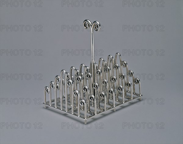 Toast Rack, c. 1880, Designed by Christopher Dresser, English, born Scotland, 1834-1904, Manufactured by James Dixon & Sons Ltd., Sheffield, England, 1835-1976 (following the firms of James Dixon, 1806-1829 and James Dixon and Son, 1829-1835), Sheffield, Silver, 14.6 × 13.7 × 10.2 cm (5 11/16 × 5 3/8 × 4 in.)