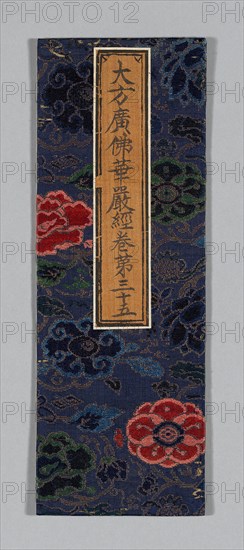 Sutra Cover, Ming dynasty (1368–1644), c. 1590s, China, Silk and gold-leaf-over-lacquered-paper strips, satin weave with patterning wefts, wrapped over cardboard and partially backed with paper, applied label of silk, plain weave, with inscribed title painted and/or printed with ink, 34 × 12 cm (13 3/8 × 4 3/4 in.)