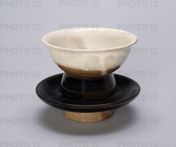 Cup and Cupstand, Song (960–1279) or Jin dynasty (1115–1234), c. 12th century, China, Northern blackware, Cizhou type, glazed stoneware with dark bronze glaze (saucer), white slip under transparent glaze (cup), H. 7.6 cm (3 9/16 in.), diam. 10 cm (4 9/16 in.)