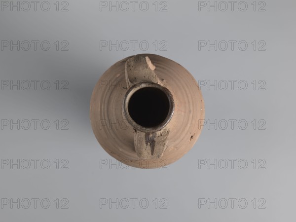 Amphora, unknown Egyptian workshop, amphorae, Egyptian amphoras, Egyptian ceramics, storage vessels, Coptic vessels, amphoras, amphoras, Nile clay, inscribed amphoras, inscribed vessels. Wine transport vessel with a strongly elongated belly, narrowed in the middle. Roller-shaped vices, approximately oval in cross-section, are glued to the central section of the neck with a straight rim. These connect to the upper section of the convex, steep shoulders. The base is conical and conically terminated. The entire surface of the vessel, brown and even, is covered with grooves of varying density and profile. The interior was impregnated with a black resinous substance, streaks of which are visible in the upper part of the neck. The clay is brown, alluvial Naqlun AC1A ceramic body type. On the upper part of the arms, between the vises, is an inscription in red paint: ICX. On the lower part of the arms, below the inscription, is a hollowed-out hole with a diameter of approximately 0.5 cm. 2nd h...