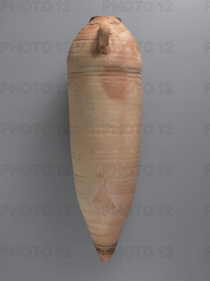 Amphora, unknown Gazan workshop Gaza Strip place of manufacture, amphorae, LRA4 amphorae, transport vessel, storage vessel. Large LRA 4 amphora of a spindle-shaped form, almost cylindrical in the central part. Arms hemispherical; lower part conical and flat-topped. Rim weakly accentuated, rounded, with slightly thickened edge. Two loop handles placed in the upper part; lower parts reinforced by clay underpinning. Ceramic fabric probably contains limestone inclusions particles visible on surface. Outer surface beige-orange, upper part covered with soaked clay to obtain a rough surface. Ribs visible in upper and lower parts; deep grooves in the bottom part. Interior coated with black resin impregnation, some of which has leaked onto the shoulder. Near one handle, a small, barely visible Coptic inscription in black ink; a large inscription in red paint runs along the vessel. Previously compared with published amphorae of the same type from Edfu. Dated 4th quarter of the 6th–7th century. F...