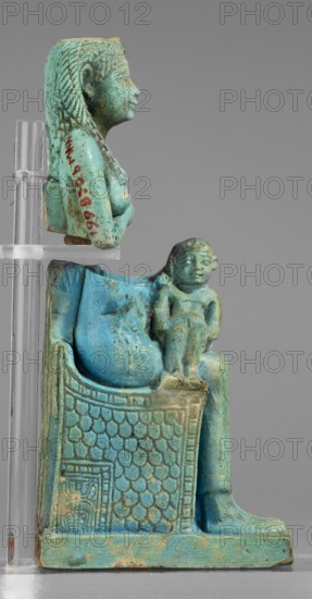 Figurine of the goddess Isis nursing Horus; Harpocrates myth., Isis myth.; Egyptian deities; female figurine; Egyptian art; 664–332 BC, Late Period, Egypt; figurine;, A turquoise-blue statuette of a seated female figure with detailed braided hair and a wig profile, shown in two views on a transparent support; the figure sits on an ornate chair with a textured scale-like pattern and decorative border, and a small childlike figure sits on her lap facing forward; colors visible include shades of turquoise-blue, greenish-blue, pale green, darker green spots, and areas of beige or light brown wear on the base and raised surfaces, with a neutral gray background and clear plastic support.