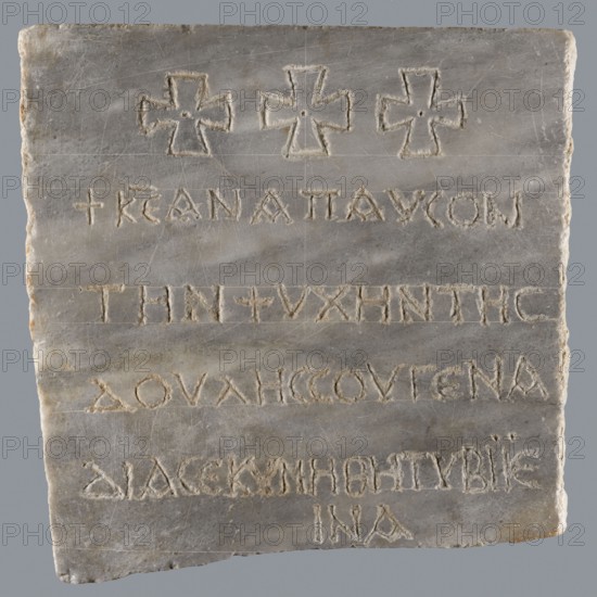 Epitaph of Gennadii, inscriptions, Greek inscriptions, tombstone, fine-crystalline blue-gray marble. The lower edge of the slab is chipped; the preserved part is cracked transversely halfway up. In the upper part, above the inscription, three Maltese crosses are arranged symmetrically. Inscription in five lines, rounded letters, 1.5–2.0 cm high, average line spacing 2.5 cm. 6th–7th century, Constantinople, Byzantine Empire 476–1453. Greek inscription, epitaph. Height 29.5 cm, width 29.5 cm, depth 2.0 cm., A rectangular stone slab with rough edges showing a worn surface in shades of gray and off-white, featuring a group of three carved cross shapes near the top and a series of incised linear grooves across its face; the carved areas reveal slightly lighter and more textured stone, and the slab displays subtle streaks and patches of darker gray and faint beige along its edges.