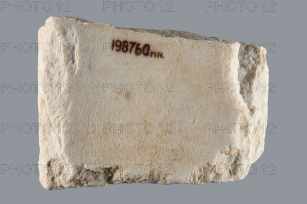 Euphemia's Epitaph, Greek inscriptions, tombstone inscription. Preserved central fragment of a white marble slab; top and bottom chipped but inscription intact. In the center a large cross with almost equal arms widening at the ends; inscription placed between the arms. Rounded letters between marked thin lines; letter height 1.5–2.1 cm, average line spacing 0.2 cm. Inscription from Bithynia or Constantinople. 6th–7th century, Asia Minor. Greek inscription, epitaph stele. Height 15.0 cm, width 20.5 cm, depth 3.2 cm., A roughly rectangular pale stone slab with a textured, uneven surface and rough, chipped edges against a gray background; the slab shows shades of off-white, cream, beige, and a few light brown spots, with a small area of darker brown near the top and some shadowed grayish crevices along the sides.