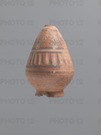 Bottle, Egyptian workshop; painted Coptic pottery, painted pottery with geometric decorations. Low, wide, annular foot; belly walls widely flared at the bottom, bent inward at approximately one-third of the vessel; neck reflected. Decoration painted in black and white, banded: below the neck a zigzag band painted in white adorned with a diagonal black check motif; below that a strip of vertical lines painted alternately with black and white paint, framed at top and bottom by double black stripes. LRO type. Nile clay, low porosity, with distinct golden mica flakes. 6th century, Egypt; vessel. Height 17.5 cm, width 11 cm body, diameter 8 cm outer rim., An earthenware vessel with a rounded, tapering form and a small, irregular base is shown against a plain gray background; the vessel's surface is primarily terracotta with areas of faded orange and brown, and it is decorated with painted bands and geometric motifs in darker brown and pale beige tones, including a crisscross pattern near th...