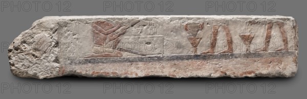 Fragments of wall decoration from the mastaba of the dignitary Tepemankh, Niuserre ruler of Egypt; ca. 2445–2421 BC, Tepemankh ca. 2445–2421 BC, provenance noted, sacrificial artists, scribes, mastabas, shipwright iconography, Egyptian architecture, sepulchral funerary architecture, scenes of boat building and bringing funerary offerings, c. 2445–c. 2421 BC; Old Kingdom, 5th Dynasty Nyuserre's reign, Abusir, bas-relief; height 26 cm, width 302 cm, depth 16 cm, weight 140 kg, A rectangular stone relief fragment with rough, weathered edges shows carved figures and objects in shallow relief on a mostly light beige surface with areas of reddish-brown and gray. On the left, a kneeling figure with visible arms and torso is colored with reddish-brown pigment and faces a low rectangular block that has carved details on its top; the figure's legs and a long object lie along the base. Toward the center and right, a row of partial standing legs and feet appear in reddish-brown pigment, each set a...