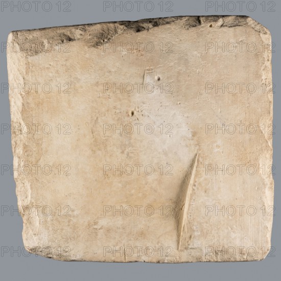 Greek dedicatory inscription, unknown author. Quadrangular limestone tablet with eight lines of Greek text. Abydos; Greek inscription. Height 36.5 cm, width 39.0 cm, depth 7.1 cm. Date: 25.06.257. Tombstone/inscription., A roughly square, flat stone slab with an uneven, worn surface in shades of beige, cream, tan, and light brown set against a gray background; the slab shows a few shallow indentations, a narrow angled groove, slightly rounded and chipped edges, and subtle variations in texture and color across its face.