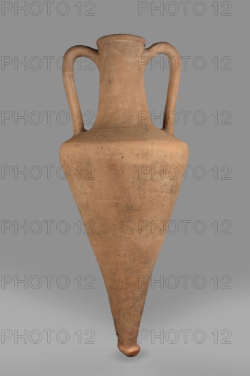Transport amphora, Slightly sloping shoulders. High and narrow neck, narrowing at the top and ending in a spout. Thick, ribbon-shaped handles, divided by a groove. In the center—a recess pressed with a finger in wet clay. 1st half of the 4th century BC, Thasos. Vessel, transport amphora. Height 66 cm, diameter 23 cm., A tall pottery vessel with a narrow pointed base and a wider rounded shoulder, featuring a tall neck and a pair of curved handles rising from the shoulder to the rim; the surface shows a worn, matte texture with small spots and patches of darker discoloration; visible colors include shades of light brown, tan, and subtle darker brown areas against a neutral grey background.