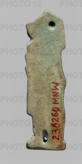Amulet - Hapi. Relief figurine of Hapi—one of the Sons of Horus. Hapi is shown in right profile as a mummy-like figure with a baboon's head covered by a wig, holding a scroll of fabric in front of him. The back is smooth with two holes for attaching the figurine. Part of a set of four Sons of Horus. Late Period–Ptolemaic Period, 664–30 BC, Egypt. Amulet; height 4.6 cm, width 1.4 cm., A roughly rectangular carved object with irregular, wavy edges and a slightly tapered top and bottom, shown against a plain pale gray background. The surface of the object is mainly a weathered green-blue with areas of brownish tan and darker green patina, and it has a few small rough pits and worn spots. There are two rounded holes near the top and bottom ends and a small raised bump near the upper middle. The object appears smooth in some areas and textured in others, with subtle variations of green, blue, tan, brown, and muted gray tones.