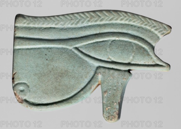 Amulet - udjat eye;, Amulet in the shape of an udjat eye with very carefully carved details; the eyebrow is carved in a herringbone pattern. A hole for a thread runs across it. The amulet is in the form of a very thick plate. Light blue glaze. Protective amulet, grave goods. Date: 664–525 BC; Late Period, 26th Dynasty, Egypt. Place of origin: Berytos. Materials/type: amulet. Dimensions: height 3 cm, width 4.5 cm, depth 0.9 cm., A carved object shaped like a stylized eye with smooth, rounded contours and raised linear ridges, showing a central almond-shaped eye area and a curved lower sweep with a short downward extension; the surface is primarily pale turquoise with areas of lighter blue-green and small patches of darker green and brownish spots, with a few worn and slightly rougher areas exposing tan or beige undertones.