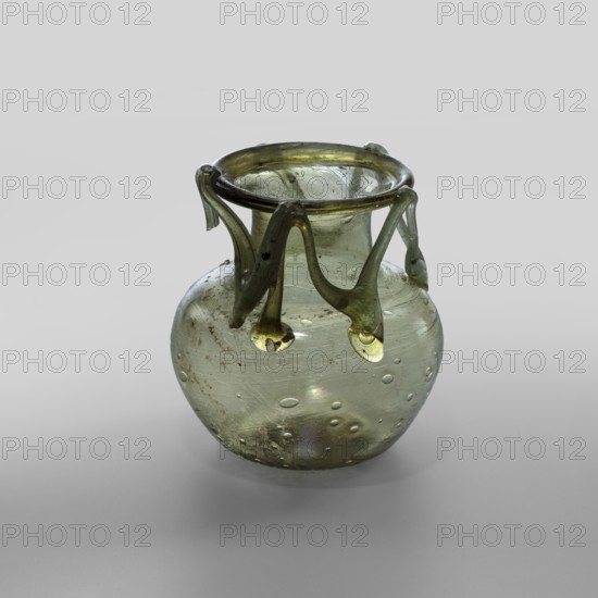 Flask, unknown eastern workshop, glass vessel, miniature vessel, Type: Barag type VI:9. Transparent yellowish-green glass with applied thread decoration between the arms and the rim edge in the form of 10 sharp bends; free-blown. Outer diameter of the rim: 5.50 cm. Bottom diameter: 3.90 cm. 4th century, Roman Empire 27 BC–476. Vessel, weight 0.076 kg., A small rounded glass vessel with a bulbous body and a narrow neck topped by a flared rim, made of translucent pale green glass with a few darker green accents; a decorative applied wavy band encircles the neck and drips down in several pendant teardrop-like shapes, the applied glass showing slightly deeper green tones; the body contains a few trapped air bubbles and small surface irregularities and shows subtle iridescent sheen and areas of mild cloudiness; the background is a smooth neutral gray gradient.
