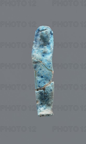 Shabti, mummy-shaped figurine, funerary gift. Legs missing. Arms crossed on the chest. Hands invisible under the shroud. Smooth tripartite wig. Facial details invisible. Not inscribed. 664–332 BC Late Period, Egypt. Height 3.7 cm., A small upright figurine-like object with a rough, weathered surface in shades of bright blue, pale blue, and turquoise with scattered darker blue spots, showing visible cracks and chips; the top is rounded and slightly bulbous, the middle tapers and then widens toward the lower section, and the base is flatter and more irregular, all set against a solid grey background.