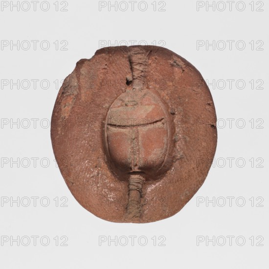Scarab mold, scarab mold cast, ; scarabs, ca. 1550–30 BC, New Kingdom–Ptolemaic Period, Egypt; mold; height 1 cm, width 3 cm, depth 2.8 cm, A round, slightly irregular object with a textured surface in shades of reddish brown and clay, featuring a raised, oval central form with a vertical seam and horizontal band, and a short ribbed stem extending from the bottom of the central form; the surface shows rough, pitted areas and subtle variations of darker and lighter reddish brown, with a plain light gray background.