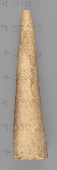 Mosaic cone; decorative architectural element from the decoration of facades of cult buildings. Mosaic cones; Sumer, Uruk culture; 4th millennium BC. Southern Mesopotamia place of origin/finding., element of architectural decoration., A tall tapered cone-shaped object with a textured, sandy surface in beige and light brown tones set against a flat gray background.