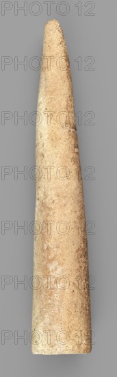 Mosaic cone, mosaic cones; ; decorative elements; Sumer; Near Eastern architecture; Eastern Gallic Scenography; 4th millennium BC; Uruk culture, Sumer; Southern Mesopotamia; element of architectural decoration, A single elongated, tapered cylindrical object with a rounded tip and a flat base, shown against a plain gray background; the object's surface is textured with a grainy, slightly pitted appearance and displays a range of beige, tan, and light brown tones with small darker speckles and subtle lighter patches.
