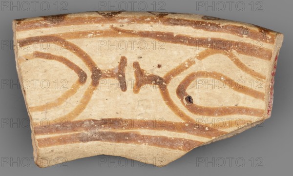 Fragment of a bowl, unknown northern Mesopotamian workshop; bucranium ornament; painted pottery with geometric ornaments; Eastern Gaulish Scenery; Upper fragment of the bowl wall with the preserved rim and geometric decoration painted on both sides. On the outer side, a simple geometric ornament consists of two parallel red bands of different widths, separated by an empty stripe on a cream-colored background. On the inner side, in a band bounded by horizontal lines, are two highly schematic, linearly stylized bucraniums bull heads with horns, arranged base to base. The narrow rim is decorated with painted, irregularly rounded triangles, their bases resting on the outer edge. The painted decoration was made before firing, from carefully polished ferrous clay, applied to a dry and very smooth layer of glaze that covered the vessel's surface. After firing, the painting acquired a color ranging from red to dark brown, while the glossy background is cream-colored. Ca. 6500–5500 BC; Halaf cu...