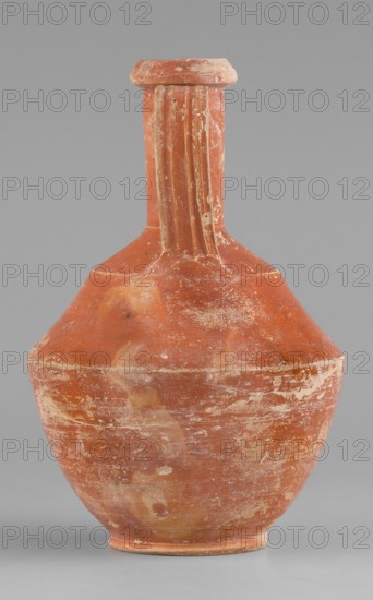 Amphora, unknown Roman workshop, Roman pottery, 1st–2nd century, Rome; Gaul France. Vessel amphora. Height 14.6 cm, width 9.6 cm., A worn terracotta vessel with a tall narrow neck and a rounded body sits against a plain gray background; the surface shows patches of faded orange-red, lighter beige areas, and hints of white residue, with a few vertical ridges on the neck and uneven weathered textures and scratches across the body.