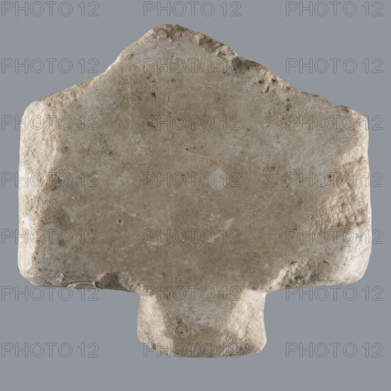 Greek dedicatory inscription; Horus myth.; tombstone inscription; Late Roman Empire period, Egypt; Greek inscription; height 12.1 cm, width 13.4 cm, depth 1.2 cm;, A roughly rectangular stone object with irregular, worn edges and a protruding base, shown against a plain gray background; the stone surface is mostly light beige with areas of off-white, pale gray, and small darker brownish spots, and it has a slightly rough, pitted texture with subtle color variations and scuff marks.