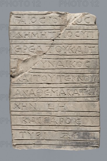 Greek inscription of thanksgiving, tombstone inscription, 30.12.23 BC, Egypt, Greek inscription, height 24.0 cm, width 14.0 cm, depth 5.8 cm, A rectangular pale stone slab with a rough, uneven surface and carved horizontal grooves across its width, showing a diagonal chip and break near the upper middle left and a few small undulations along the edges; the slab is primarily light gray to off-white with subtle darker gray smudges and areas of shadow, and the carved recesses appear slightly darker than the surrounding stone.