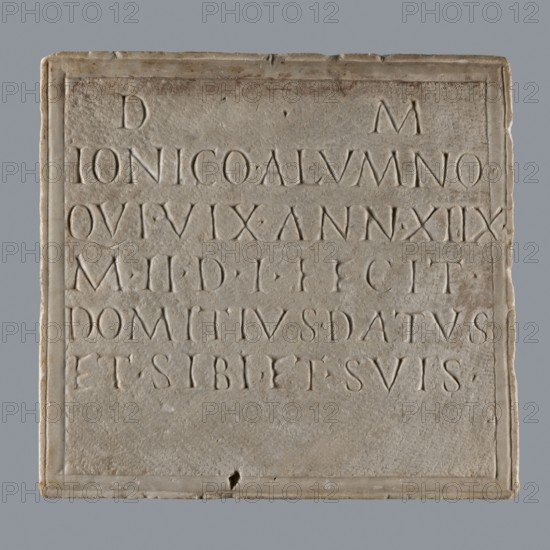 Latin grave inscription, unknown author, 2nd century, Roman Empire 27 BC–476, slab epitaph, grave inscription; height 31 cm, width 28 cm, A square stone plaque with a recessed rectangular panel and a raised border, showing a weathered surface in shades of light gray, beige, and off-white; within the panel a group of carved letterforms are arranged in horizontal lines, their incised shapes creating shallow shadows of slightly darker gray; the plaque edges are slightly rounded and chipped in a few places, and there are faint brownish stains and small pits on the stone surface; the background behind the plaque is a smooth mid-gray.