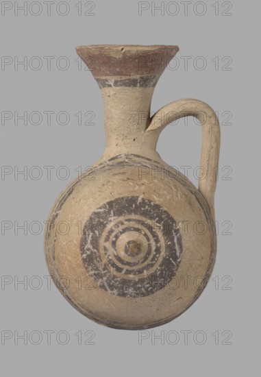 Cypriot gourd jug, Excavated at Nea Paphos Cyprus. Cypriot pottery, Cypriot Bichrome Ware III. Small vessel with a barrel-shaped gourd-shaped body, without a foot, with a spherical bottom. On both shorter sides the center is marked with a small protruding point. A single ring-shaped handle on the longer side, mounted above half the height of the body and at the base of the neck, curved downwards. Quite long neck, strongly flaring, conical spout. Yellow clay with yellow-brownish engobe. Decoration in black-brown and matte red: the spout is decorated externally with a wide matte red band with a narrower black band beneath; the belly has on both sides two groups of three concentric black-and-brown lines of varying widths and spacing, the outer line in the groups on the shorter sides being much wider than the others. Protruding points are marked in black-and-brown. Date: 850–700 BC. Type/place of origin: Cyprus; vessel., A rounded clay vessel with a narrow neck and a flared rim, featuring ...