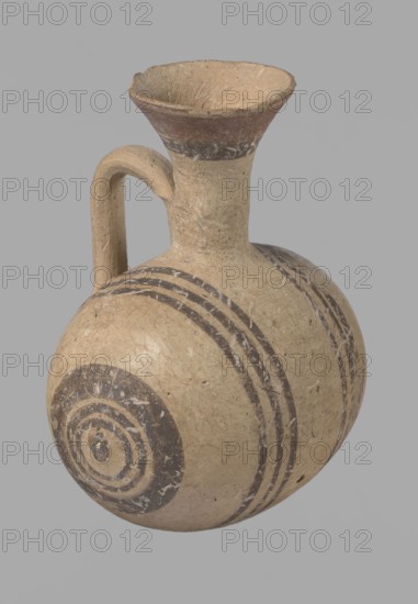 Cypriot gourd jug, Excavated at Nea Paphos Cyprus. Cypriot pottery, Cypriot Bichrome Ware III. Small vessel with a barrel-shaped gourd-shaped body, without a foot, with a spherical bottom. On both shorter sides the center is marked with a small protruding point. A single ring-shaped handle on the longer side, mounted above half the height of the body and at the base of the neck, curved downwards. Quite long neck, strongly flaring, conical spout. Yellow clay with yellow-brownish engobe. Decoration in black-brown and matte red: the spout is decorated externally with a wide matte red band beneath a narrower black band; the belly is decorated on both sides with two groups of three concentric black-and-brown lines of varying widths and spacing, with the outer line in the groups on the shorter sides much wider than the others. Protruding points are marked in black-and-brown. Dated 850–700 BC. Vessel from Cyprus., A rounded ceramic vessel with a narrow neck and flaring rim, featuring a single...