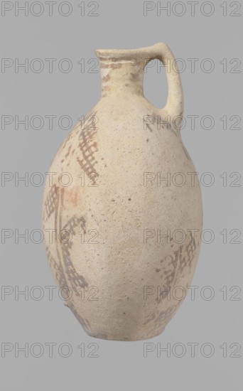 Jug, Bronze Age Cypriot White Painted I jug 1800–1650 BC; Middle Cypriot period II–III, from Cyprus. Large oval flattened belly, indistinct foot, sloping shoulders, low narrow neck with thickened outer edge of the spout. Small cylindrical vertical handle attached to shoulders and spout, protruding slightly above spout edge. Orange-cream clay with cream engobe; painted geometric decoration in brown. Neck: zigzag bands of three parallel horizontal lines between each band highest at spout edge. Body: vertical stripes bounded by lines; centers of sides feature a single-line zigzag; between them two zigzags with a grid pattern four meshes wide. Bottom: continuous horizontal line intersects the delimiting lines. Condition: slight loss at rim; surface heavily worn and decoration poorly preserved in many places., A rounded pottery jug with a narrow neck and a single curved handle, shown against a plain grey background; the jug has a textured surface in beige and light tan with areas of darker ...