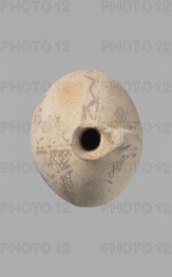 Jug, Excavated at Nea Paphos Cyprus. Cypriot pottery, Bronze Age Cypriot White Painted I. Jug with a large, oval, flattened belly, indistinct foot, sloping shoulders, low narrow neck with thickened outer edge of the spout. Small cylindrical vertical handle attached to the shoulders and spout, protruding slightly above the spout edge. Orange-cream clay with cream engobe. Painted geometric decoration in brown: neck with zigzag bands of three parallel horizontal lines between each band highest at spout edge; body with vertical stripes bounded by lines, centers of the sides with a single-line zigzag; between them two zigzags with a grid pattern four meshes wide. A continuous horizontal line at the vessel bottom intersects the delimiting lines. Condition: slight loss at rim; surface heavily worn and decoration poorly preserved in many places. Date: 1800–1650 BC, Middle Cypriot period II–III. Origin: Cyprus., An oval, light beige ceramic vessel with a rounded body and a small central opening...