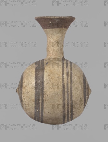 Cypriot gourd jug, A small vessel with a barrel-shaped gourd-shaped body, without a foot, with a spherical bottom. The center is marked with a small protruding point on both short sides. A single handle on the long side, mounted at the greatest bulge of the body and at the base of the neck, bent at a right angle. Quite long neck, strongly flaring, conical spout. Neck and handle slightly offset from the vessel axis; the handle is mounted at a slight angle, with a very clear trace of finger pressure on the right side where it is attached to the neck. Reddish-brown clay. Yellowish-brownish engobe. Decoration in black-brown and matte red. The rim is decorated externally with a wide matte red band. The body is decorated on both sides with two groups of three concentric black-brown lines, of varying widths and spacing. In the groups on the shorter sides, the outer line is much wider than the others. Protruding points are marked in black-brown. Preservation condition: cracked and glued neck a...