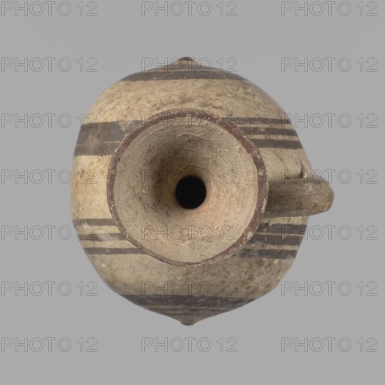 Cypriot gourd jug, Cypriot pottery, gourds, Cypriot Bichrome Ware III. A small vessel with a barrel-shaped gourd-shaped body, without a foot, with a spherical bottom. The center is marked with a small protruding point on both short sides. A single handle on the long side, mounted at the greatest bulge of the body and at the base of the neck, bent at a right angle. Quite long neck, strongly flaring, conical spout. Neck and handle slightly offset from the vessel axis; the handle is mounted at a slight angle, with a very clear trace of finger pressure on the right side where it is attached to the neck. Reddish-brown clay. Yellowish-brownish engobe. Decoration in black-brown and matte red. The rim is decorated externally with a wide matte red band. The body is decorated on both sides with two groups of three concentric black-brown lines, of varying widths and spacing. In the groups on the shorter sides, the outer line is much wider than the others. Protruding points are marked in black-bro...