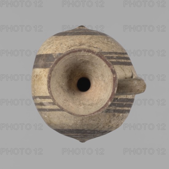 Cypriot gourd jug, A small vessel with a barrel-shaped gourd-shaped body, without a foot, with a spherical bottom. The center is marked with a small protruding point on both short sides. A single handle on the long side, mounted at the greatest bulge of the body and at the base of the neck, bent at a right angle. Quite long neck, strongly flaring, conical spout. Neck and handle slightly offset from the vessel axis; the handle is mounted at a slight angle, with a very clear trace of finger pressure on the right side where it is attached to the neck. Reddish-brown clay. Yellowish-brownish engobe. Decoration in black-brown and matte red. The rim is decorated externally with a wide matte red band. The body is decorated on both sides with two groups of three concentric black-brown lines, of varying widths and spacing. In the groups on the shorter sides, the outer line is much wider than the others. Protruding points are marked in black-brown. Preservation condition: cracked and glued neck a...