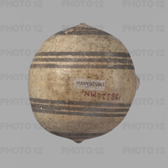 Cypriot gourd jug. A small vessel with a barrel-shaped gourd-shaped body, without a foot, with a spherical bottom. The center is marked with a small protruding point on both short sides. A single handle on the long side, mounted at the greatest bulge of the body and at the base of the neck, bent at a right angle. Quite long neck, strongly flaring, conical spout. Neck and handle slightly offset from the vessel axis; the handle is mounted at a slight angle, with a very clear trace of finger pressure on the right side where it is attached to the neck. Reddish-brown clay with a yellowish-brown engobe. Decoration in black-brown and matte red. The rim is decorated externally with a wide matte red band. The body is decorated on both sides with two groups of three concentric black-brown lines, of varying widths and spacing. In the groups on the shorter sides, the outer line is much wider than the others. Protruding points are marked in black-brown. Preservation condition: cracked and glued nec...