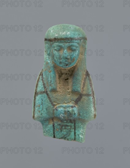 Ushabti, Mummy-shaped figurine, preserved upper fragment from the waist up. Arms crossed on the chest, hands placed at the same level, next to each other, holding hoes in both hands. Rectangular basket on the back. Long, smooth, three-part wig with a headband; triangular face with proportional details; eyes slightly closed. Headband and facial details painted. Painted inscription in a column separated by vertical lines on the front of the legs, starting just below the folded hands; text illegible. c. 945–c. 715 BC, Third Intermediate Period, 22nd–23rd Dynasty, Egypt. Height 5.8 cm., A small turquoise-colored figurine against a plain gray background showing a stylized human-shaped form with a rounded head and straight hair or headdress falling to the shoulders, a visible face with closed or softly defined eyes and a small nose, and a torso with arms folded or held at the front; the surface shows areas of rough texture and weathering with some brownish and darker greenish spots and lines...