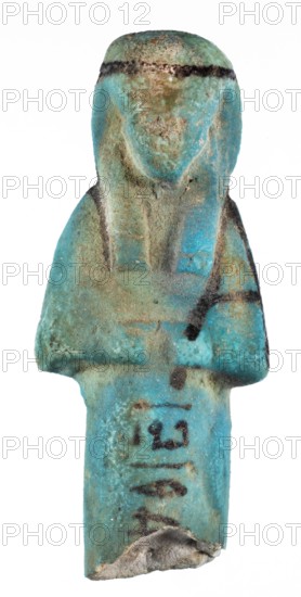 Shabti with baskets on the back, Mummy-shaped funerary figurine, preserved fragment from the knees up. Arms crossed on the chest, hands level next to each other holding hoes. Rectangular basket slung on strings over both shoulders on the back. Long, smooth three-part wig with a headband; triangular face, proportional details, eyes slightly closed; painted facial details and headband. Painted inscription in a column separated by vertical lines on the front of the legs beginning just below the folded hands: ...of the soul belonging to Osiris.... ca. 1069–715 BC, Third Intermediate Period, 21st–23rd Dynasty, Egypt. Shabti, height 7.6 cm, width 3.2 cm., A small sculpted figure photographed against a white background, showing a stylized torso and head with a rounded top and a flattened base; the surface is worn and pitted with a rough texture. The piece displays a turquoise-blue overall color with areas of greenish-blue and pale green patina, along with patches of brownish tan and sandy bei...