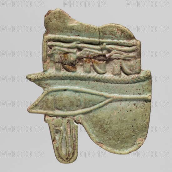 Amulet - Udzhat eye with a lioness;, Udzhat eyes; udjat Eye of Horus and lioness/uraeus iconography; protective amulet used as grave equipment; ca. 945–664 BC, Third Intermediate Period, 22nd–25th Dynasty, Egypt; height 3.6 cm, width 3.8 cm, A greenish, weathered amulet fragment with a matte, speckled surface showing shades of pale green, turquoise, brown, and tan, shaped with a horizontal central eye-like raised motif and a rounded lower lobe; the top edge is irregular with carved relief details including a braided band and draped forms, while the lower portion shows a narrow hanging element with vertical elongated ridges and a chipped edge, and small dark spots and worn areas scattered across the piece.