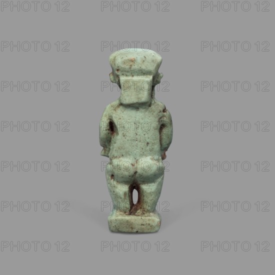 Amulet - Ptah the Dwarf Pataikos, Ptah the Dwarf myth., Egyptian deities, Egyptian religion, amulets. Amulet depicting Ptah the Dwarf Pataikos as a naked, dwarfish man standing with legs slightly apart, hands placed on his sides. Figure on a rectangular base with a hole for hanging behind the neck. 664–332 BC; Late Period, Egypt. Amulet; height 4.3 cm, width 1.7 cm., A small statuette viewed from the back, carved in a pale bluish-green material with areas of darker green and brown discoloration; the figure has a blocky head with a squared rear extension, short arms hanging at the sides, a rounded back and buttocks, and short legs standing on a rectangular base; the surface shows speckled spots and patches of brownish weathering against the predominant bluish-green, and the background is a uniform medium gray.
