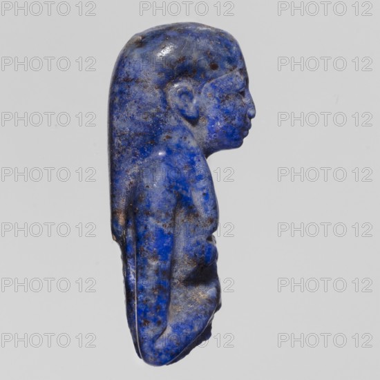 Fragment of an Isis figurine, Isis mythology, Egyptian deity; votive figurine/amulet, New Kingdom, Egypt, ca. 1550–1069 BC; figurine, height 3 cm, width 2 cm., A small carved figure shown in profile with a long rounded head and stylized hair that falls down the back, rendered in vivid blue with darker blue and brown speckling and patches across the surface, smooth polished texture with some rougher areas, a defined ear, nose, lips, chin, shoulder, and torso sculpted in low relief, set against a pale neutral background.
