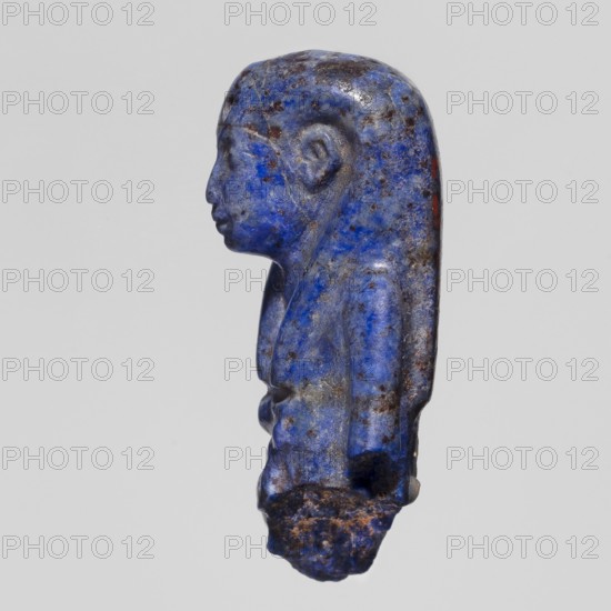 Fragment of an Isis figurine, Isis mythology, Egyptian deity, votive figurine or amulet, New Kingdom, Egypt, ca. 1550–1069 BC; figurine, height 3 cm, width 2 cm, A small carved figure shown in profile with a rounded head and elongated back, rendered in vivid blue with mottled darker blue and brown spots; the figure has a smooth forehead, a pronounced nose and lips, a carved ear, and a defined chin and neck, while the torso displays sculpted shoulders and a bit of the upper chest with subtle surface variations; the lower portion appears rougher and irregular with earthy brown texture, and there are small areas of darker brown and a hint of red along the back against a neutral light gray background.