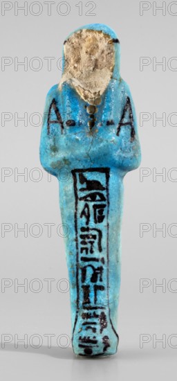 Amenhotep's shabti with baskets on the back; hieroglyphs; headbands; wigs; baskets; hoes; grave goods; mummy-shaped figurine. Arms crossed on the chest, the right folded over the left, holding hoes in both hands. On the back is a rectangular basket with loops. Painted tools. Wears a three-part, long, smooth wig with a headband; ears covered; face damaged; painted headband. Painted inscription in one column on the front of the legs: Osiris the father of God ... scribe of the temple of Amun-Re, Amenhotep. Ca. 1069–715 BC; Third Intermediate Period, 21st–23rd Dynasty, Egypt. Shabti; height 13.3 cm, width 4.2 cm., A small, upright figurine made of a bright turquoise-blue material with a rounded head and a simple stylized body, the head area showing an exposed rough beige surface where the blue coating is worn away, the torso and lower body covered in darker blue and black painted linear markings, the surface showing small cracks and areas of darker discoloration, set against a neutral ligh...