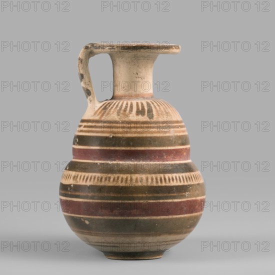 Italo-Corinthian aryballos, geometric motifs, Etruscan pottery, 600–575 BC, Etruria, aryballos vessel, weight 0.054 kg, height 7.7 cm, diameter 5.3 cm, An earthenware vessel with a rounded, bulbous body and a narrow neck topped by a flat, outward-flaring rim, featuring a single curved handle connecting rim to shoulder; the surface shows alternating horizontal bands and rows of short vertical strokes in colors including beige, brown, olive green, and reddish-brown, with areas of lighter cream where the base material shows through and some dark spots and worn patches; the object sits against a plain neutral gray background.