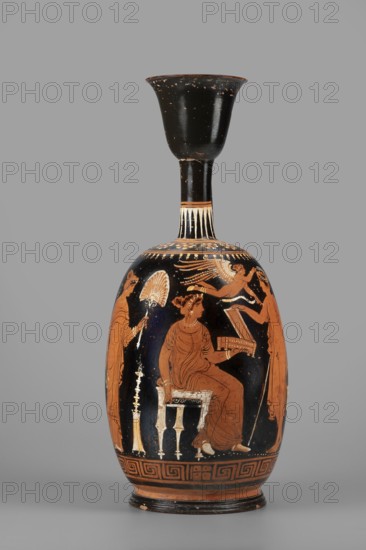 Ariballus lekythos with a depiction of a seated woman, unknown Apulian workshop, Classified Gallo-Classical Scenario, Eros mythology, Greek deities, Southern Italian ceramics, Seated woman with a casket. On the sides a youth crowned by Eros and the figure of a woman. 350–325 BC, Apulia, Ariballus lekythos, vessel, height 28.4 cm, width 12.3 cm, weight 0.520 kg, A tall, narrow ceramic vessel with a black neck and flared rim and a rounded body decorated in orange and black tones, showing a seated woman in an orange dress on a small stool, a standing figure holding a fan to her left, another standing figure to her right holding an object, and a small winged figure above; decorative bands with geometric and floral motifs encircle the shoulder and base, and a few lighter cream-colored highlights accent details on the figures and furniture against a gray background.