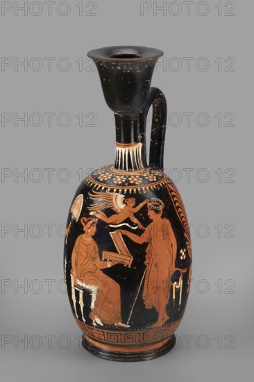 Ariballus lekythos with a depiction of a seated woman, unknown Apulian workshop, Classified Gallo-Classical Scenario. Eros mythology, Greek deities. Southern Italian ceramics. Seated woman with a casket; on the sides a youth crowned by Eros and the figure of a woman. 350–325 BC. Apulia place of finding. Ariballus lekythos vessel; height 28.4 cm, width 12.3 cm, weight 0.520 kg., A tall ceramic vessel with a long neck and flared rim sits against a plain gray background; the vessel is primarily black with areas of reddish-orange and pale cream decoration, showing a painted scene on its rounded body with figures in reddish-orange silhouettes detailed with cream highlights. The neck and handle are black with small worn spots revealing lighter undercolor, and a band of pale cream vertical strokes encircles the neck base. The main painted scene includes a seated robed figure on a small stool holding an open box, a standing robed figure holding a staff and reaching toward the seated figure, an...
