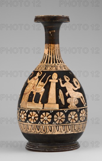 Red-figure bottle with a scene of the punishment of Marsyas, red-figure Greek pottery, 330–310 BC. Vessel glued from several fragments; minor additions on the neck, flaking of white and yellow retouches covering the silhouette of Silenus. Between the ornamental bands covering the lower half of the neck and belly, a scene depicts the punishment of Marsyas. Marsyas sits on the field of a cloak, the other end of which covers his right thigh. The lower part of his torso faces left, while the upper part, with his hands tied to a tree in front, faces right toward Apollo standing next to him. Apollo stands beside a table on a platform, holding a lyre placed on it, and in his right hand holds a taenia, a symbol of victory, which flutters above Silenus's head. A Scythian stands before Marsyas, using a knife held in his right hand, and begins to flay him. The scene is complemented by three satyrs and a column with an oval object omphalos?. The composition illustrates the musical agon between Apo...