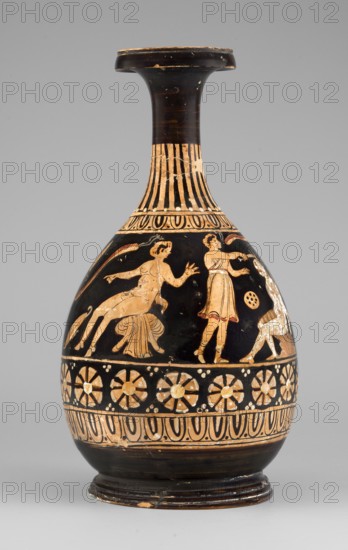 Red-figure bottle with a scene of the punishment of Marsyas, 330–310 BC. Greek pottery bottle height 26 cm, width 13.5 cm, weight 0.67 kg. Vessel glued from several fragments; minor additions on the neck, flaking of white and yellow retouches covering the silhouette of Silenus. Between the ornamental bands covering the lower half of the neck and belly, a scene depicts the punishment of Marsyas. Marsyas sits on the fold of a cloak, the other end covering his right thigh; the lower part of his torso faces left while the upper part, with his hands tied to a tree in front, faces right toward Apollo. Apollo stands next to a table placed on a platform, holding a lyre on it and a taenia in his right hand, which flutters above Silenus’s head. A Scythian stands before Marsyas, holding a knife in his right hand and beginning to flay him. The scene is complemented by three satyrs and a column with an oval object possibly an omphalos. Subject relates to the musical agon between Apollo lyre and Mar...