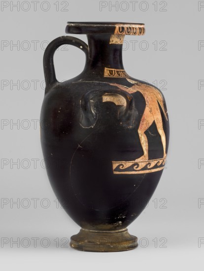 Red-figure hydria with a combat scene, Laghetto-Caivano Group c. 340–320 BC, Duel Painter 340–330 BC. Hydria decorated with a combat scene of two naked hoplite warriors fighting with long spears; they wear pointed helmets, hold round convex shields in their left hands, and wear greaves on their legs. Weaponry painted white with yellow retouching. Ca. 340–320 BC, Campania. Vessel hydria. Height 22.5 cm, width 15.6 cm, depth 13.3 cm, weight 0.612 kg., A black ceramic vessel with a single curved handle and a flared rim, showing a few areas of worn surface and scratches; a figure painted in a reddish-orange hue appears on one side standing on a decorative band, with additional small decorative motifs near the neck and rim in the same reddish-orange color; the vessel sits on a short foot that is a darker brownish color, and the background is a light gray.
