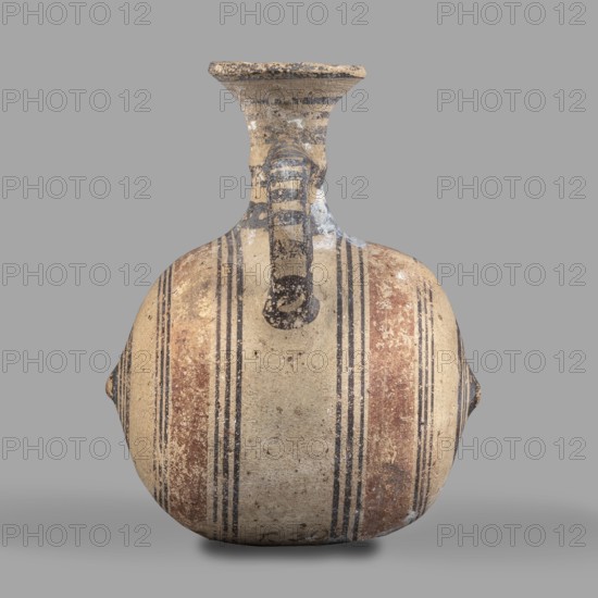 Barrel-shaped jug, unknown Cypriot workshop, ca. 850–600 BC, Cyprus Arsinoe.; vessel, height 12 cm, width 10 cm. Barrel-shaped body terminated on both sides by small protrusions. Cylindrical neck terminates in a cup-shaped spout. A band-shaped vise connects the body to the neck midway up. Decoration in brown paint: concentric bands encircling the barrel; two wide light-brown bands on either side of the vise framed by narrow dark-brown bands. At the protrusions the bands form concentric circles. Transverse bands between two vertical bands decorate the vise. A series of concentric belts on the neck. Geometric motifs; Cypriot ceramics., A rounded ceramic vessel with a narrow neck and flared rim sits against a plain gray background; the vessel shows a weathered surface with bands of paint in beige, brown, black, and faded red arranged vertically and symmetrically around the body, and a short vertical handle extending from the neck to the shoulder with striped black and beige markings; the ...